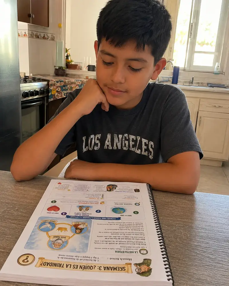 Niño usando el cuaderno Generación de Fe impreso en casa